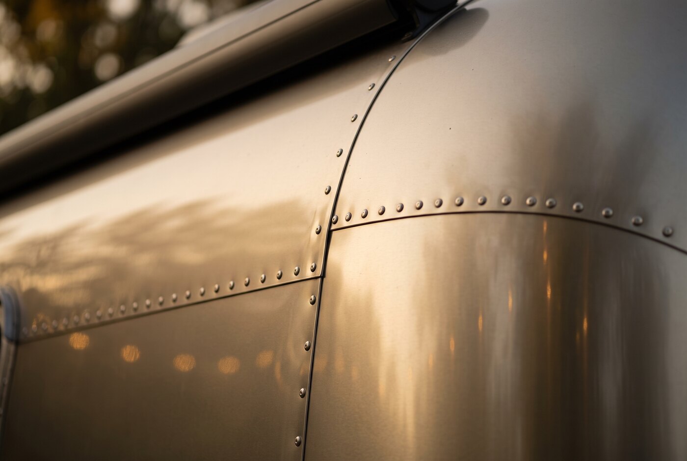 Detailaufnahme der genieteten Aluminiumhaut des Airstream im Abendlicht.