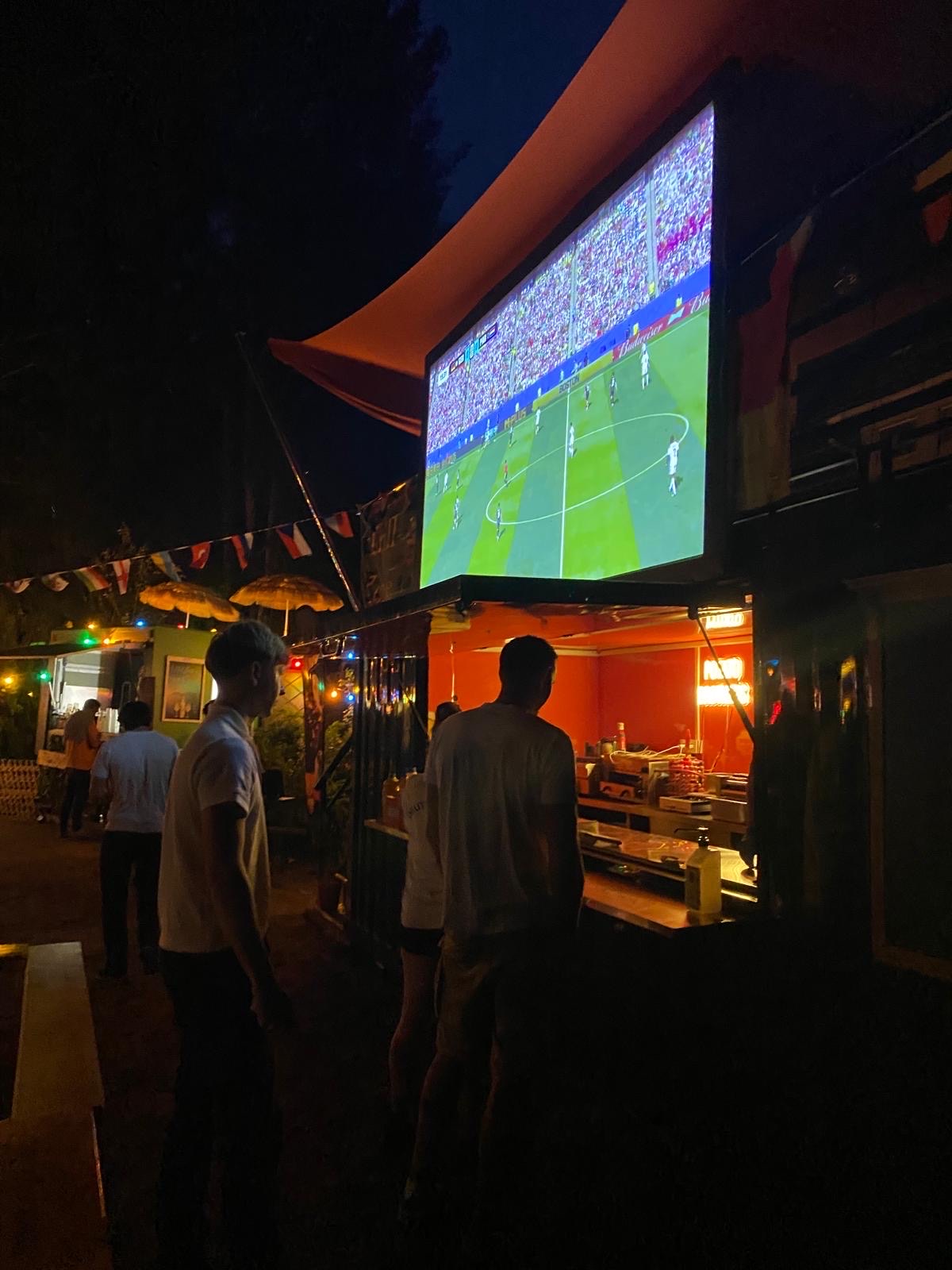 Leinwand mit Übertragung über dem Potato Brothers Container am Abend